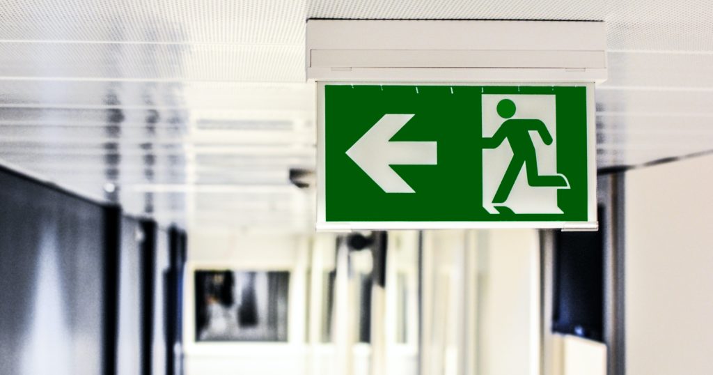 close up of green exit sign pointing to the left